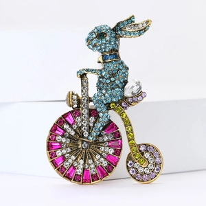 Luxe broche van een konijn op een fiets in goudlegering met kleurrijke kristallen