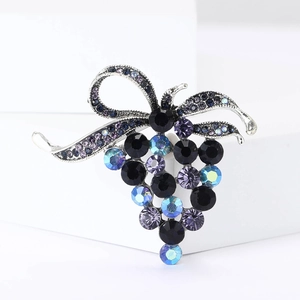 Détail de la broche vintage en forme de raisin avec strass violets et nœud argenté