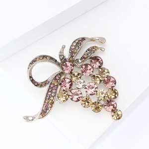 Broche de raisin exquise avec strass roses et nœud argenté sur fond blanc