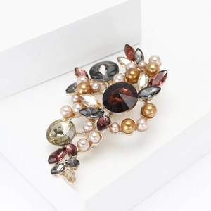 Elegant vintage alloy brooch with red crystals and pearls on white display stand