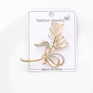 Vue détaillée d'une broche bouquet de fleurs dorées avec opales et zircons blancs