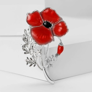 Close-up of red enamel poppy brooch with silver alloy leaves and elegant floral details
