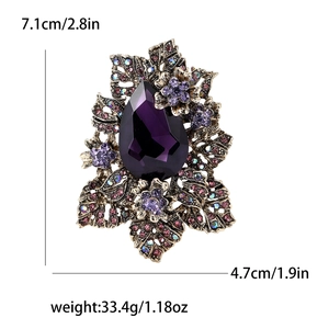 Détail d'une broche florale rétro en alliage avec cristal violet et fini vieil or