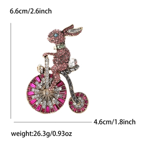 Broche lapin à vélo dorée ornée de strass roses et rouges pour costume femme