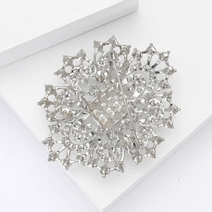 Macro shot of silver brooch back showing pin mechanism and fine metal welding details