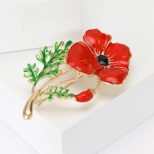 Exquisite red enamel poppy flower brooch with golden stem on a white pedestal