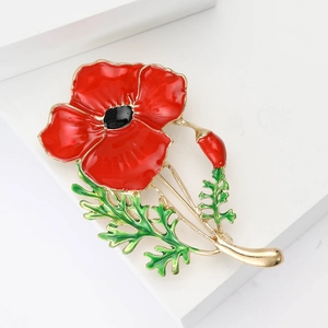 Elegant red enamel poppy flower brooch with golden stem on a minimalist white platform