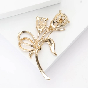 Vue détaillée de l'arrière d'une broche fleur dorée montrant l'épingle et le fini métal