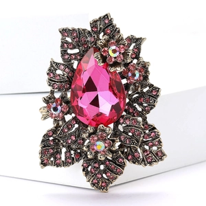 Gros plan d'une broche en bronze vintage avec grand cristal rose et détails strass