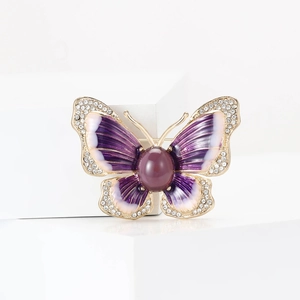 Broche papillon dorée en émail avec cristaux étincelants et grande pierre violette