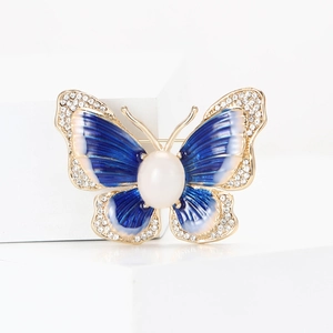 Broche papillon dorée avec émail bleu, strass blancs et perle centrale pour vêtements