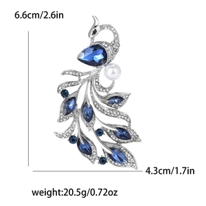 Detailed view of phoenix brooch with blue crystals, small diamonds and a white pearl accent