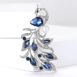 Close-up of luxury silver peacock brooch with blue rhinestones and white pearl accent