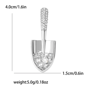 Detail view of silver shovel brooch with clear zircons including exact size and weight metrics