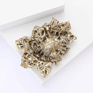 Vue arrière d'une broche feuille en bronze vintage avec motif ajouré et épingle sûre