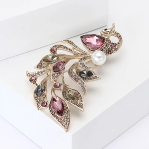 Elegant gold phoenix brooch featuring colorful crystals and a white pearl on white stone