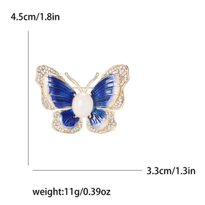 Broche papillon tendance en émail avec strass et perles sur fond blanc brillant
