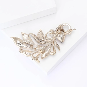 Macro view of the secure safety pin clasp and textured back of golden leaf brooch