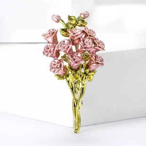Dettaglio ravvicinato della spilla a bouquet di rose rosa con foglie dorate