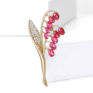Elegante spilla mughetto con cristalli rosso rosa e strass bianchi su base dorata