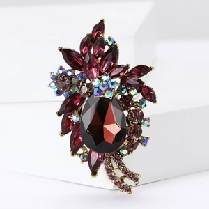 Close-up of vintage flower brooch featuring dark red crystals and gold alloy base