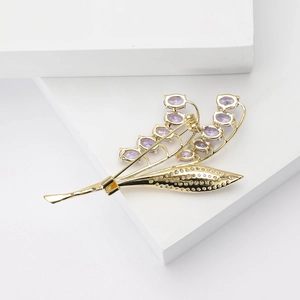 Dettaglio della spilla a mughetto in rame e zircone con petali viola eleganti