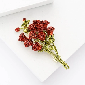 Elegante spilla a bouquet di rose in smalto rosso con foglie verdi su supporto bianco
