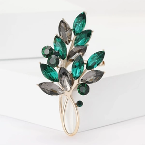 Détails des cristaux marquises verts et alliage doré sur la broche feuille