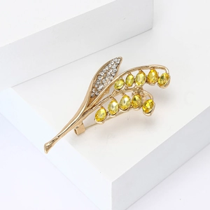 Elegante spilla a mughetto in lega dorata con gemme gialle e strass brillanti