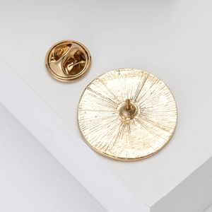 Macro detail of gold enamel pin back featuring anti-slip texture and butterfly clasp