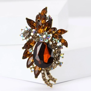 Detailed macro view of vintage gold brooch with amber crystal teardrop and rhinestones