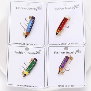 Vue détaillée de quatre broches crayons en émail coloré en bleu, rouge, vert et violet