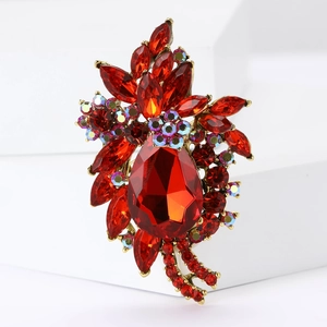 Vintage gold-plated red teardrop crystal brooch for women on a white display stand