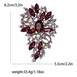 Macro detail of retro alloy brooch with deep red crystals and pink rhinestones