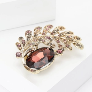 Elegant gold leaf and moon brooch with oval red stone and shimmering rhinestones