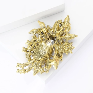 Detailed back view of gold flower brooch showing pin clasp and sparkling rhinestones