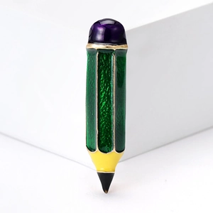 Détail d'une broche crayon en émail vert avec cabochon violet et texture métallique