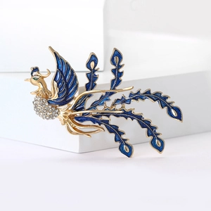 Detail of elegant phoenix brooch with blue enamel wings and sparkling rhinestones
