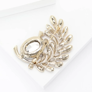 Detail view of the gold alloy leaf brooch back showing the secure pin fastener