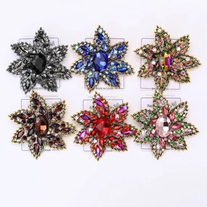 Detailed close-up showing six vintage starburst brooches in various gemstone colors
