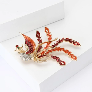 Exquisite phoenix brooch with red enamel feathers and crystals on a white pedestal