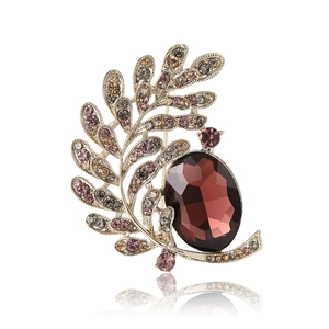 Elegant gold leaf brooch with large oval burgundy gemstone and sparkling rhinestones
