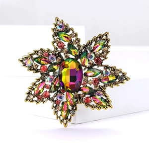 Detailed view of vintage flower brooch with rainbow crystal and antique gold finish