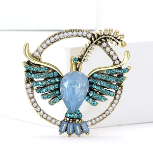Elegant dove of peace brooch in gold alloy with blue crystals and leaf detail