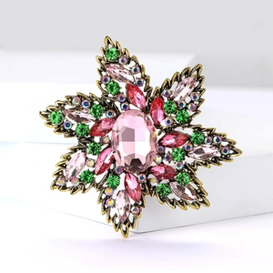 Detailed macro of vintage flower brooch with pink rhinestones and antique gold finish