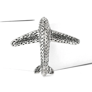 Macro detail of silver airplane brooch featuring antique hammered metal texture finish