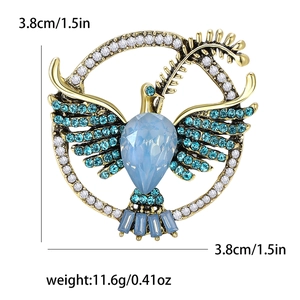 Vintage gold alloy dove brooch with blue crystals and olive branch on white background