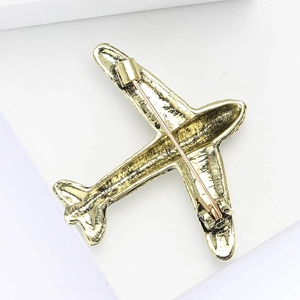 Detail of the golden alloy airplane brooch back with a secure safety pin fastener