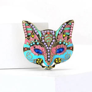 Dettaglio della spilla a maschera di volpe con strass colorati e finitura smaltata