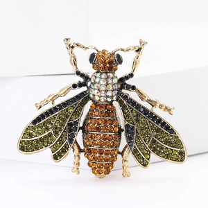 Exquisite bee brooch in vintage gold with green and amber crystals on white stand